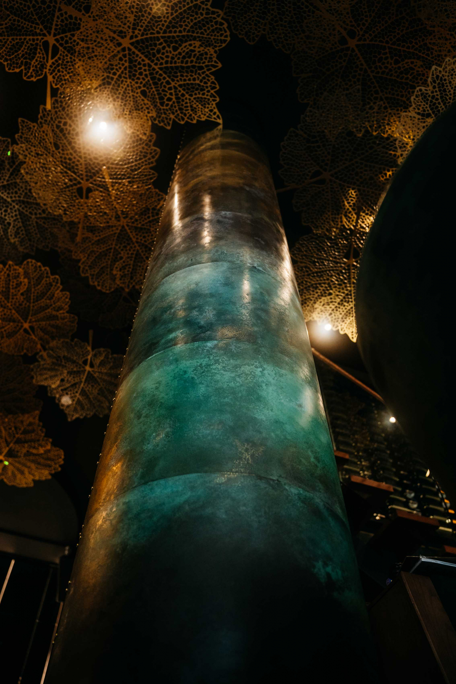 A Center piece in Qbar Johannesburg. Transformed & re-imagined pillar evolving from dark bronze colours to greens. A gradient that showcases the process & art of winemaking and the seasons we endure to make every harvest special.