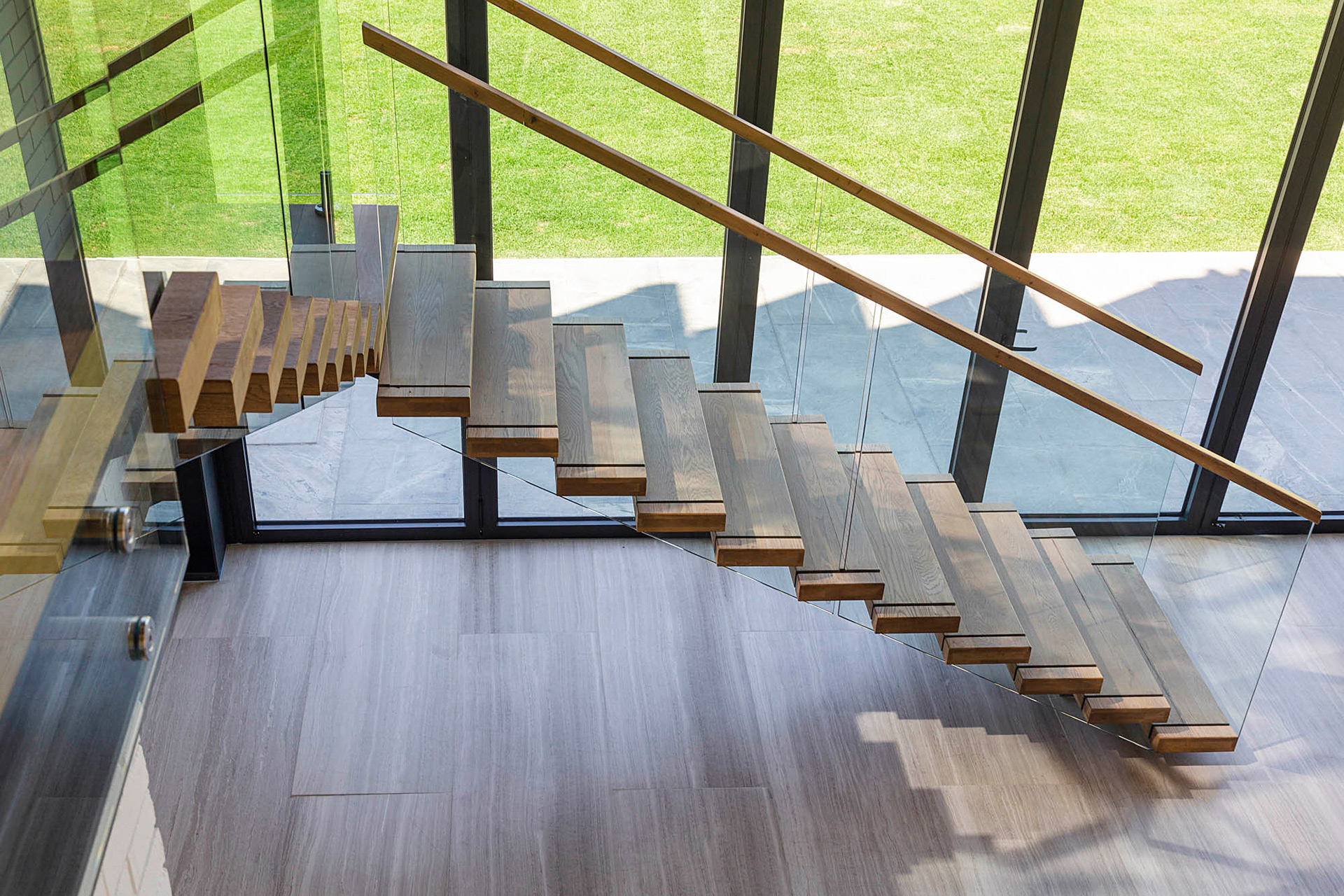 Metal staircase in the Venue Hall with wooden threads and glass balustrade