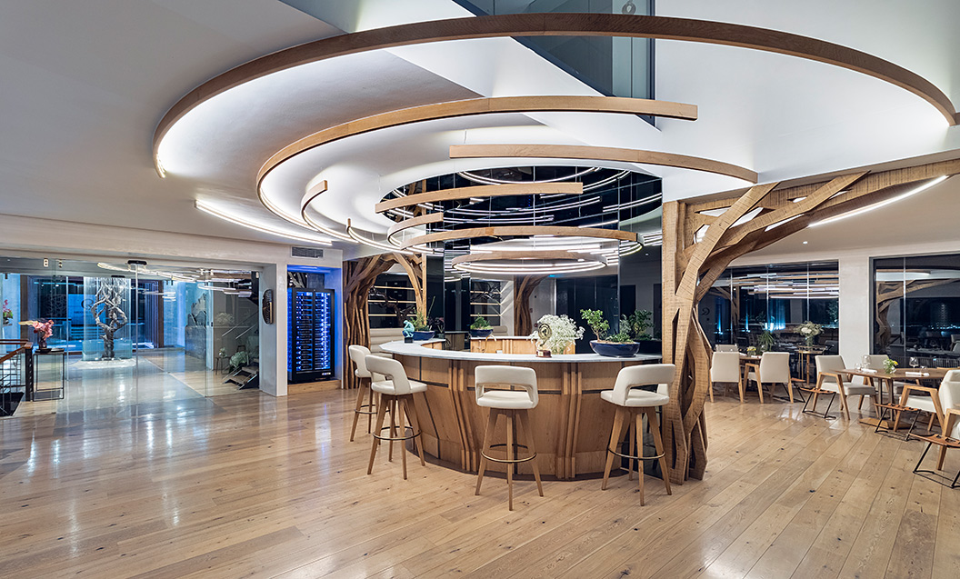 Central focus in restaurant space – solid wood Bar counter with dynamic lights composition above